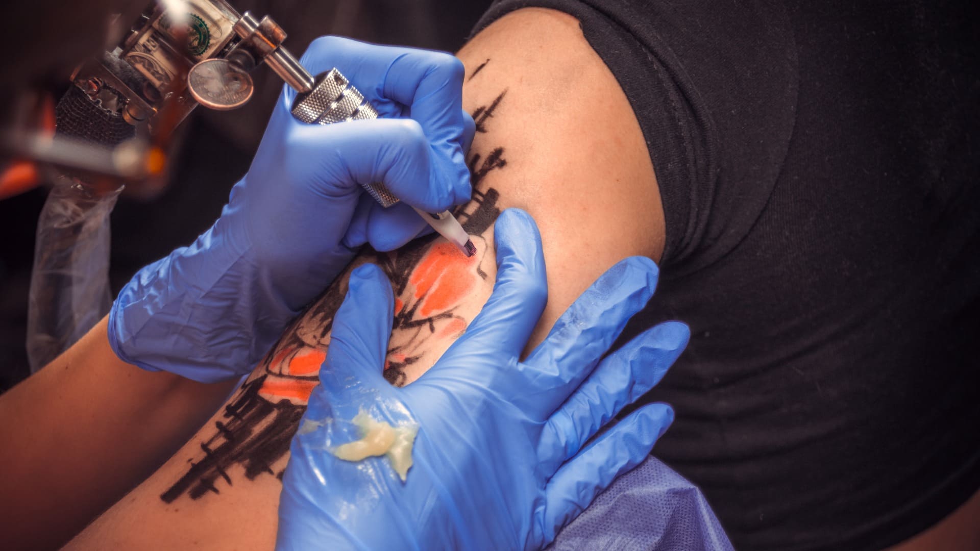 Maestro tatuador trabajando en un dispositivo de máquina de tatuaje profesional en un estudio de tatuajes